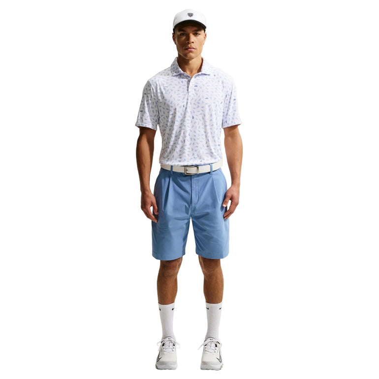 Man wearing a patterned polo shirt, blue shorts, white shoes, and a cap on a white background