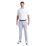 Man wearing a white polo shirt and gray pants on a white background