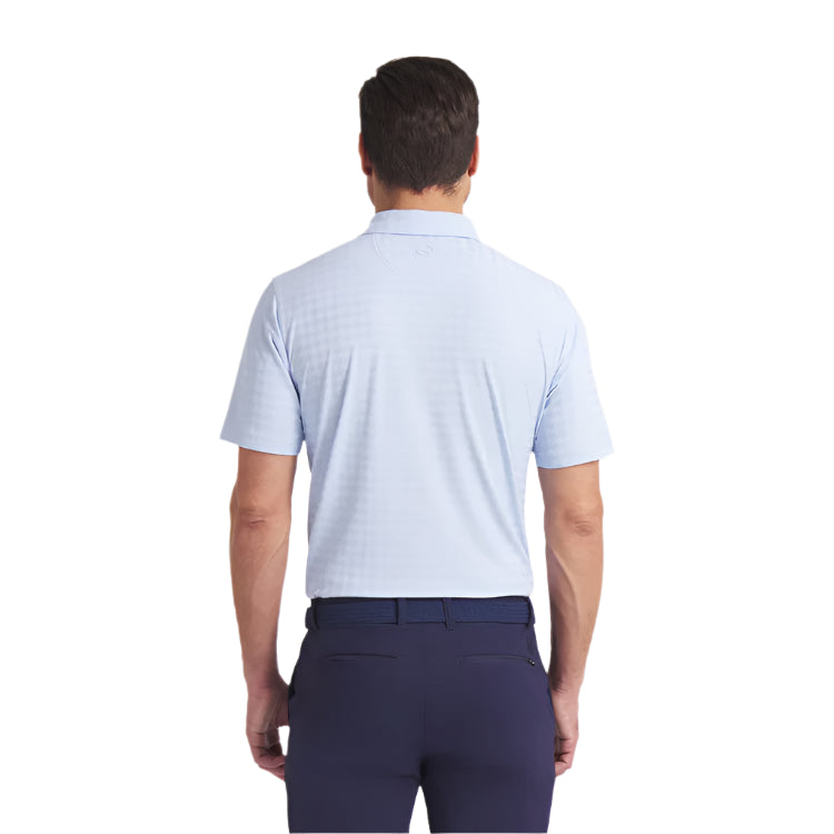 Man wearing a light blue polo shirt and dark pants on a white background