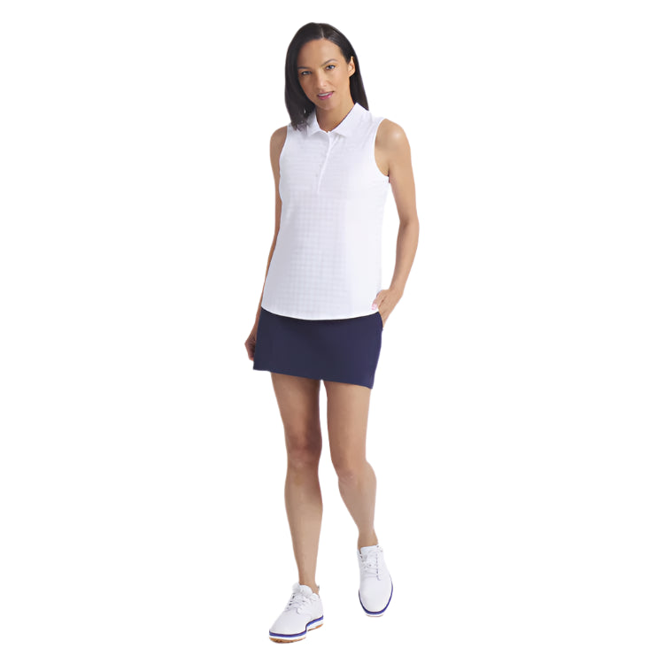Woman wearing a white sleeveless shirt and navy skirt on a white background