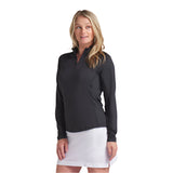 Woman wearing a black long-sleeve top and white skirt on a light gray background