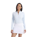 Woman wearing a light blue long-sleeve top and white skirt on a white background