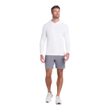 Man wearing a white long-sleeve shirt and gray shorts on a light gray background