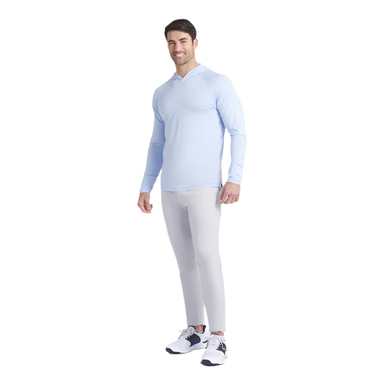 Man wearing a light blue long-sleeve shirt and white pants on a white background